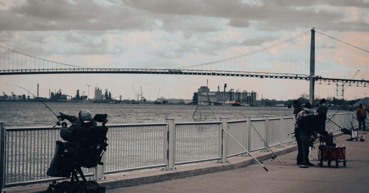 Courtyard Detroit Downtown, Detroit — A Riverfront Stay Inside the Millender Center Fishermen enjoying a cloudy day by the river near the iconic Ambassador Bridge in Detroit.