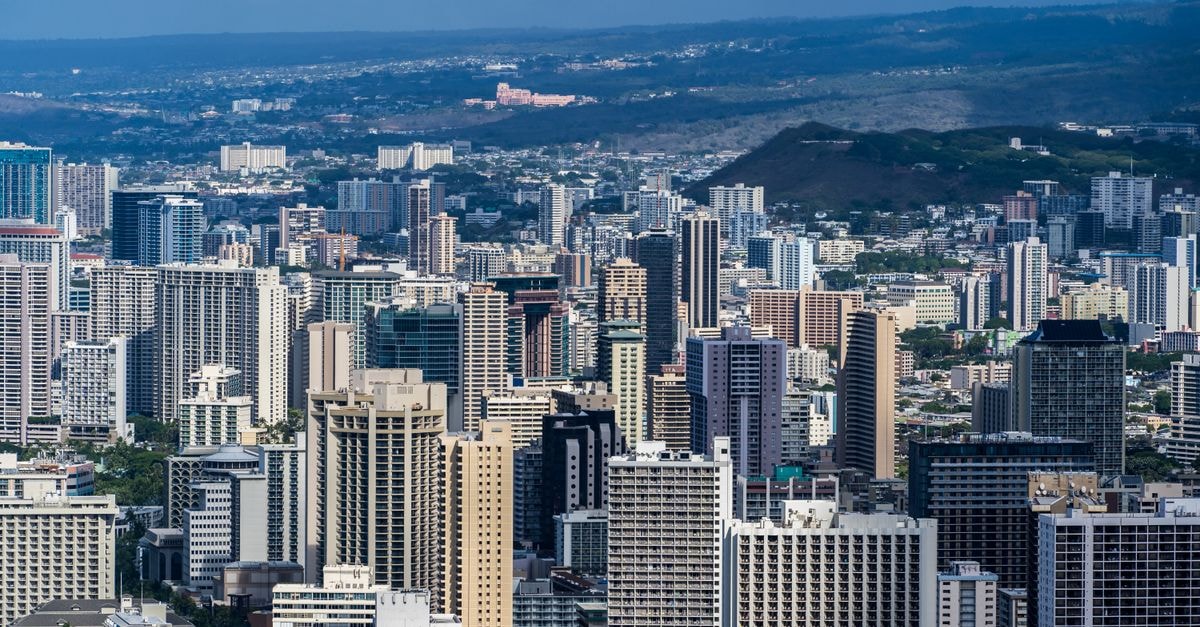Edgewater Resort & Spa in Avarua: Six Acres of Tropical Beachfront Aerial view of Honolulu's modern skyline with skyscrapers under clear blue skies.