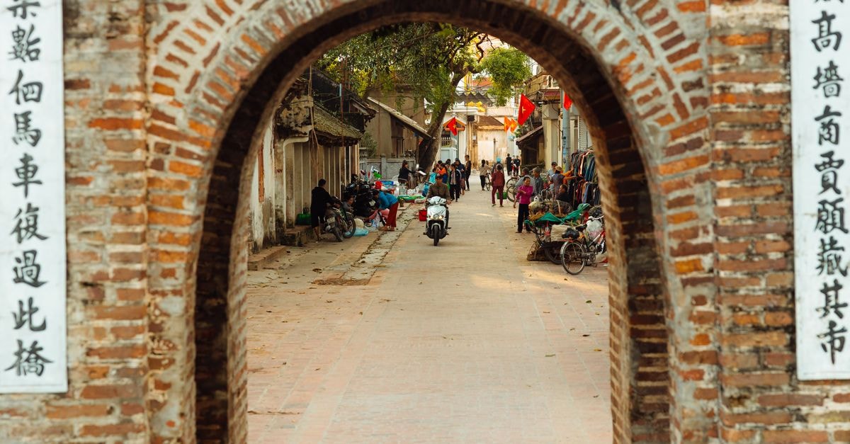 A Slow Travel Guide to Chaozhou: Tea, Archways, and Ancient Streets A vivid street scene through a historic brick archway, showcasing local marketplace activity and architecture.