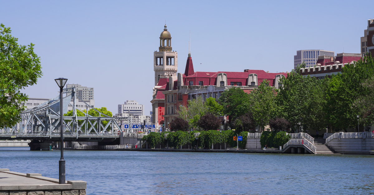 A Quiet Charmer in Northeast China: A Changchun Travel Guide Charming riverside cityscape featuring historic buildings and a bridge.