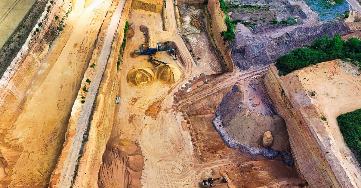 Mogotes Metals closes US$15M Rio Tinto investment and forms Filo Sur alliance Aerial view of a large sandstone quarry with heavy machinery digging and piles of sand.