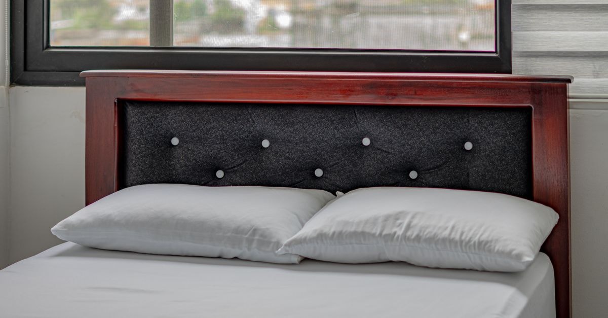 Grand Hotel Santo Domingo in Santo Domingo de los Colorados: A Modern Hotel Concept Since 1998 Modern bedroom with window view in Santo Domingo. Features a wooden headboard and comfortable bedding.