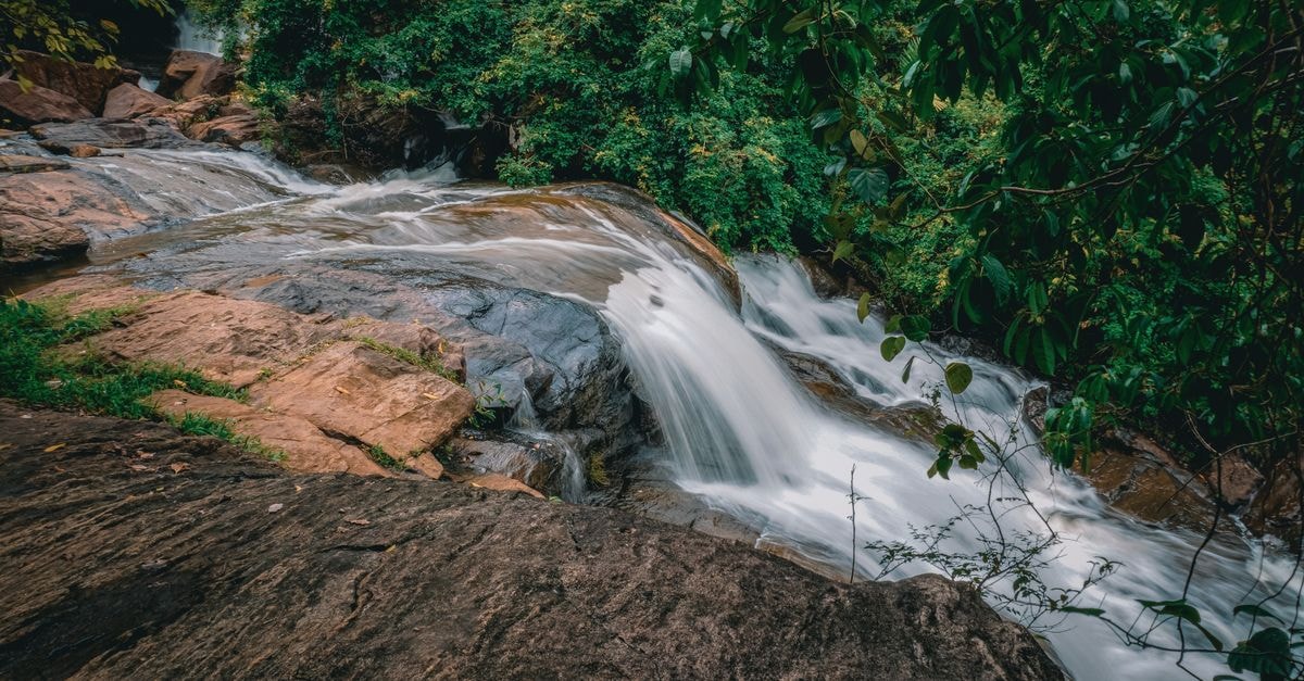 Beautiful waterfall cascading over rocks in lush green forest, Sri Lanka.