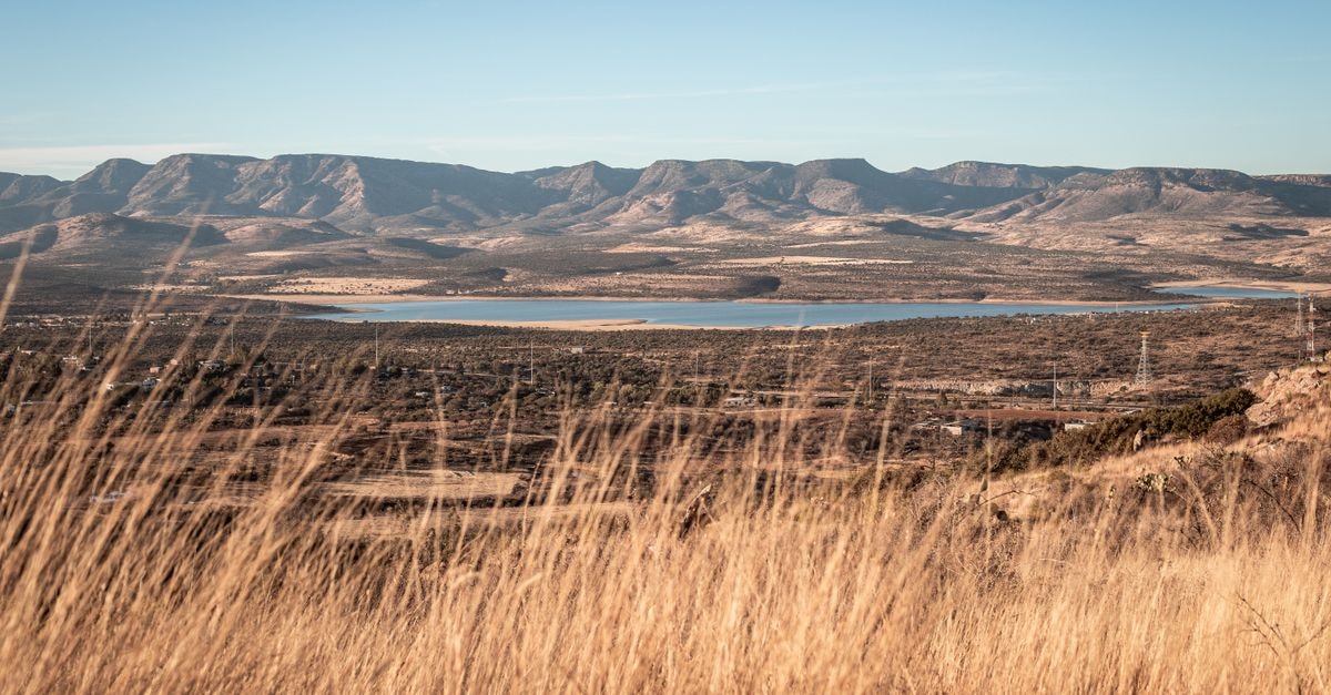 Boksburg Travel Guide: A Calm East Rand Stopover Worth Exploring Stunning view of mountains and a lake with golden grass foreground, perfect for travel inspiration.