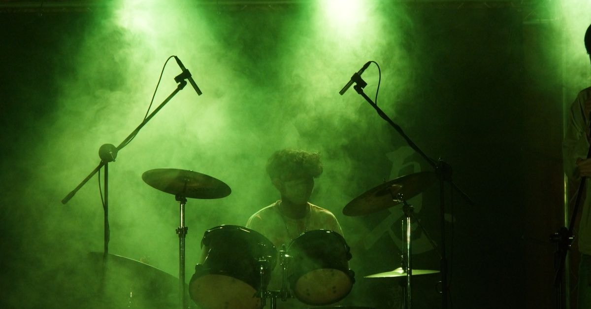 India's Ashmita Chaliha reaches maiden BWF World Tour final at Korea Masters A drummer performs on stage amid smoke and green lights, creating a vibrant concert atmosphere.