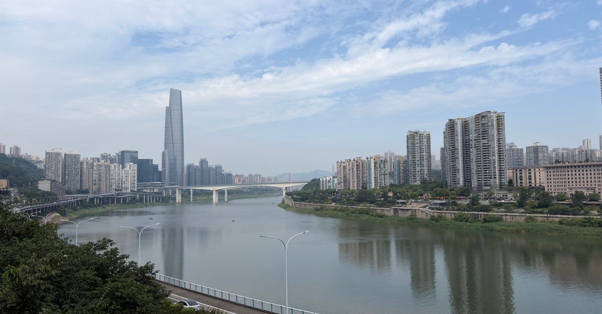 重慶天際線景觀，可見嘉陵江與現代高樓大廈，天空為多雲天氣。