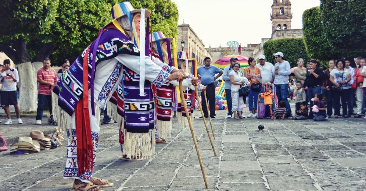 Colorful traditional dance performance in city square, showcasing cultural attire and lively atmosphere.
