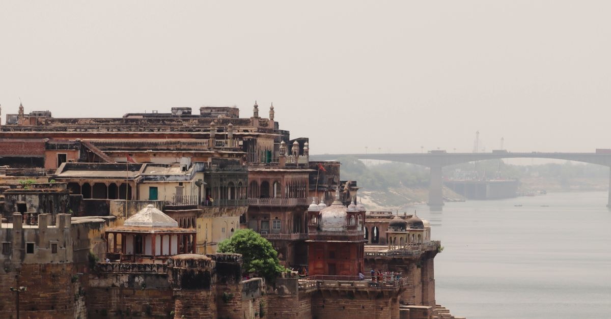 Majestic view of Varanasi's historic architecture along the Ganges River, showcasing Indian heritage.