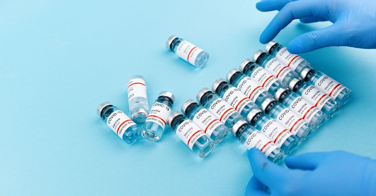 McKesson agrees in principle to extend CVS pact through 2032 Close-up image of COVID-19 vaccine vials being arranged with medical gloves on a blue background.
