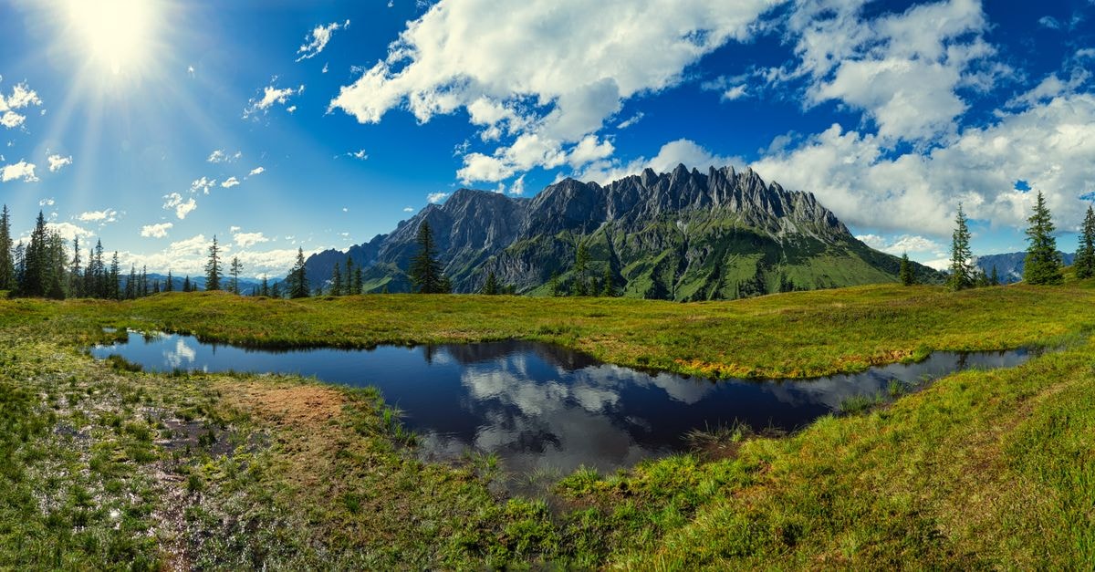 Salzburg travel guide: slow days between mountains and music Beautiful view of lush green fields and mountains in Mühlbach am Hochkönig, Austria under a clear blue sky.
