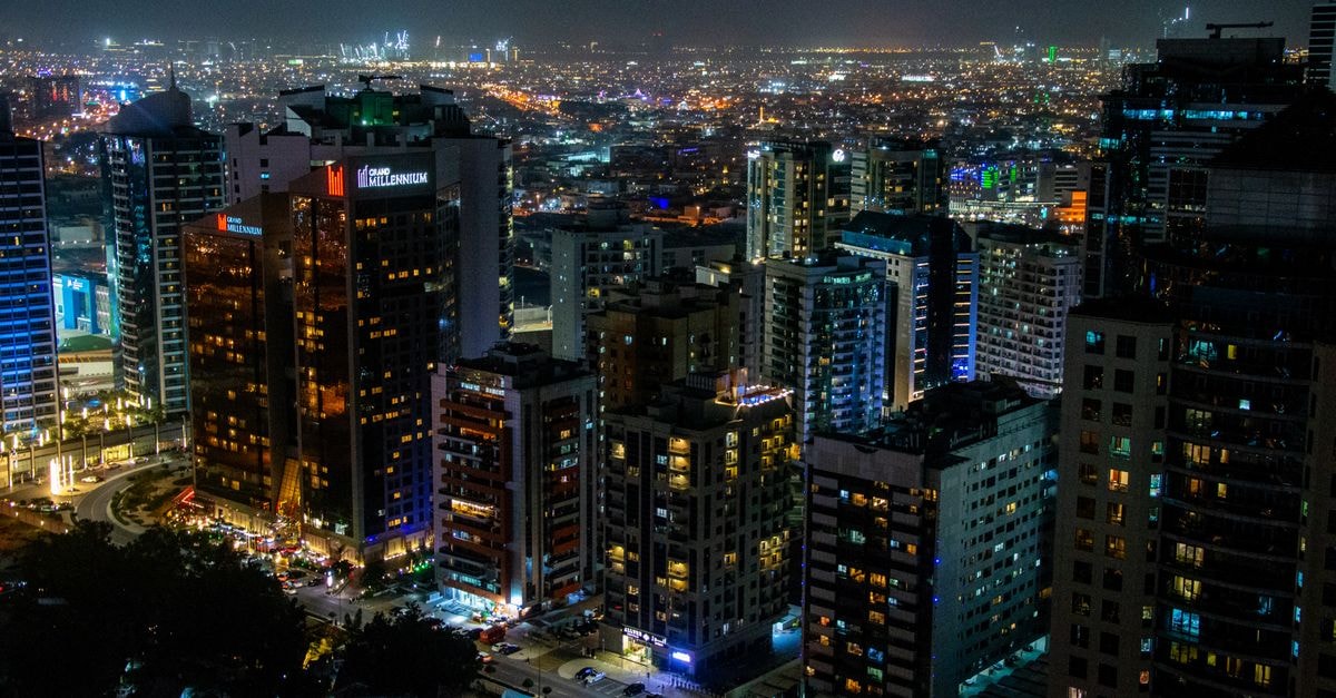 Stunning aerial view of a bustling city skyline illuminated at night, showcasing modern skyscrapers and dynamic city life.