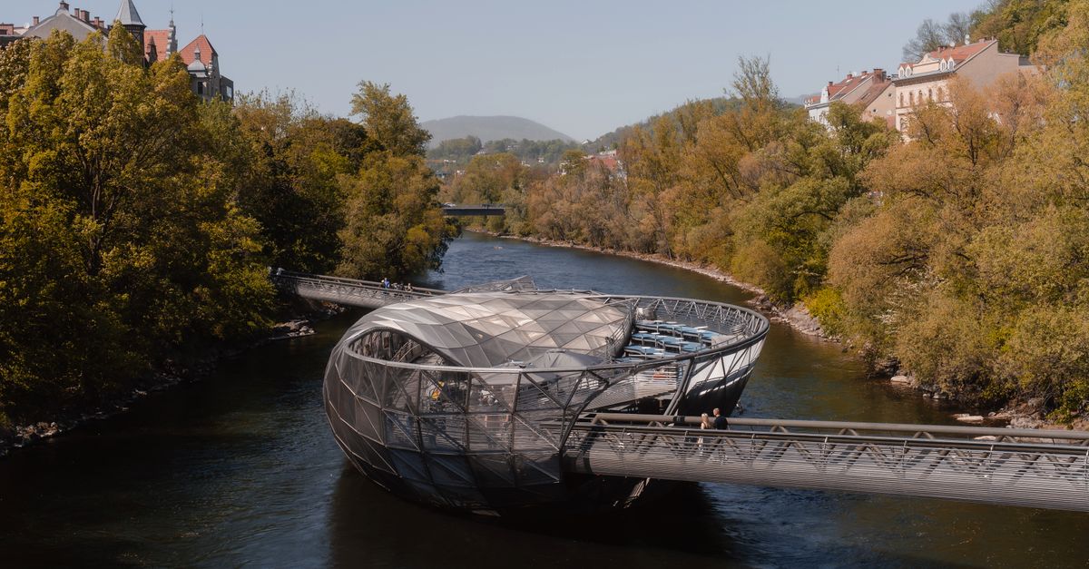 Graz Travel Guide for July 2026: Festivals, Rivers and Styrian Food Explore the unique Murinsel bridge in Graz, Austria during a serene autumn day with vibrant foliage.