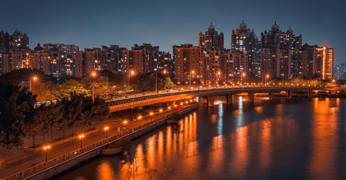 Jieyang Travel Guide: A Slow-Paced Look at a Guangdong City Beautiful nighttime view of Guangzhou cityscape with illuminated bridge and reflections in the river.
