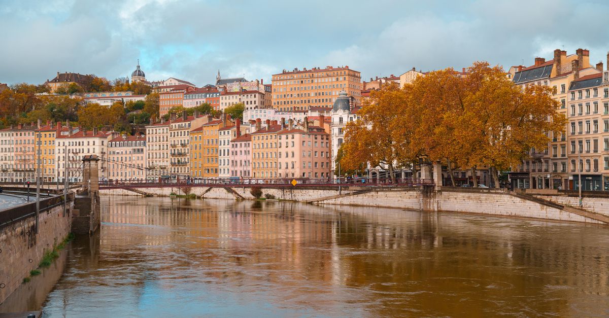 Beautiful autumn scene of the Saône River and Lyon's architecture in Auvergne-Rhône-Alpes, France.