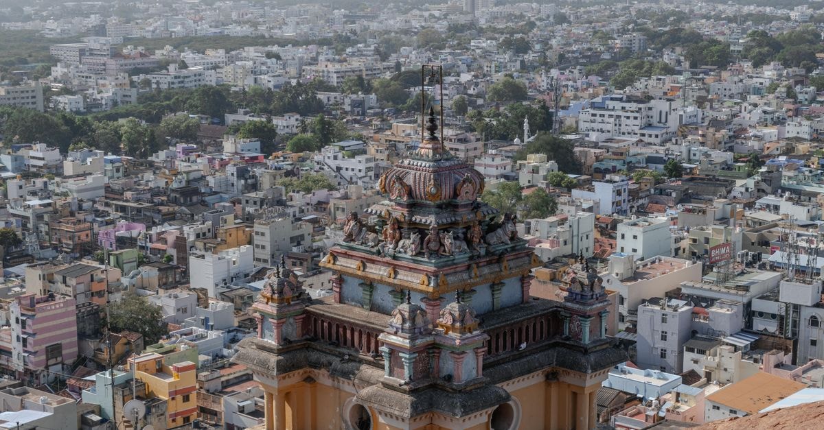 Hotel Santhi Bhavan, Chennai — Steps from Chennai Central Station A breathtaking aerial shot of Tiruchirappalli city with a focus on an ancient temple tower amidst urban landscape.