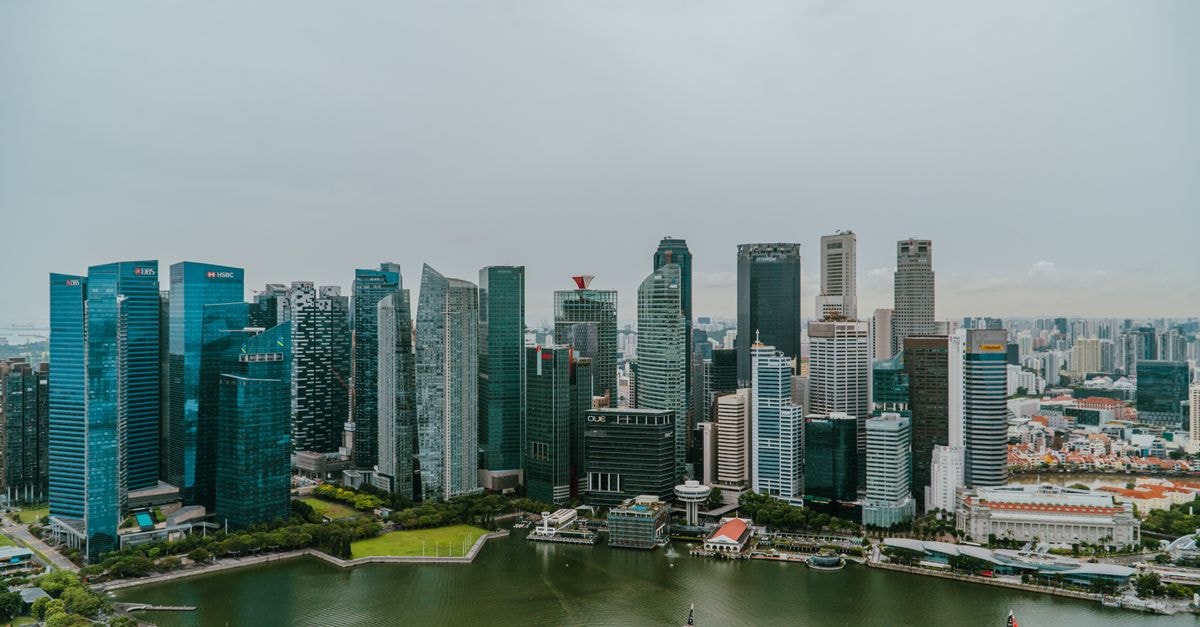 Aerial shot showcasing the modern skyline of Singapore with Marina Bay in the foreground, capturing urban architecture and water scenery.