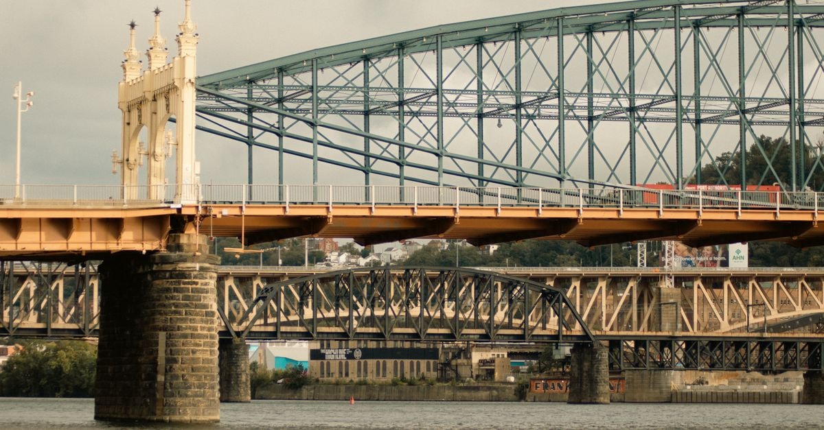 Pittsburgh Travel Guide: Planning Tips, Costs and Things to Do A view of multiple steel bridges crossing a river in Pittsburgh, showcasing urban infrastructure.