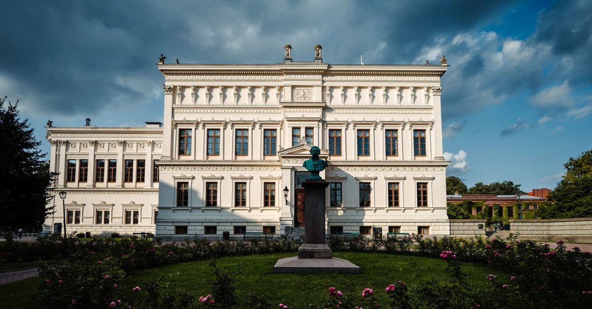 Lund Travel Guide: Planning Tips, Costs and Things to Do Beautiful neoclassical architecture in Lund, Sweden, with a scenic garden in front.