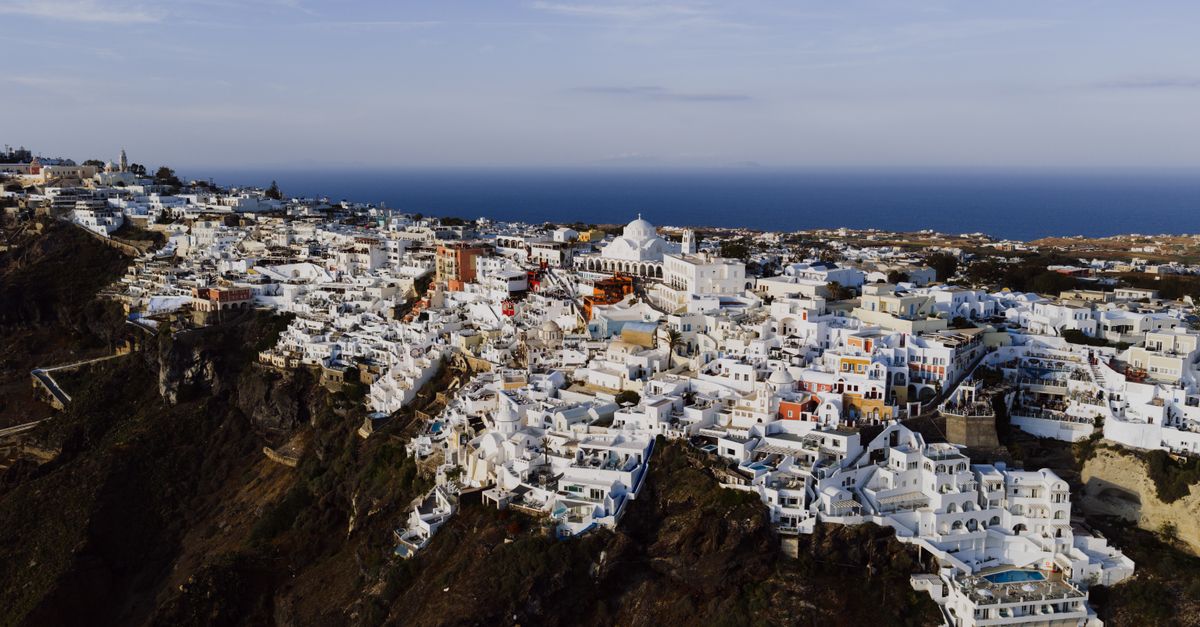 Stunning aerial view of Fira's iconic white architecture against the Aegean Sea.