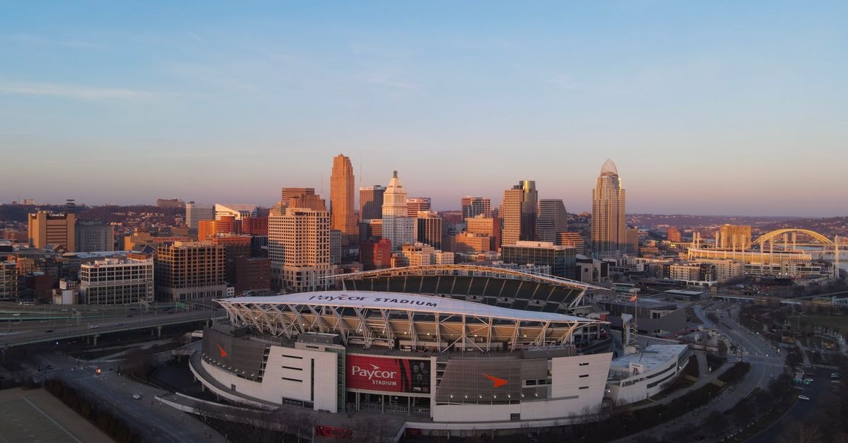 Fery wins Cincinnati return as Djokovic exits in first match since Wimbledon Aerial view of Cincinnati's skyline featuring Paycor Stadium during sunset, highlighting urban cityscape.