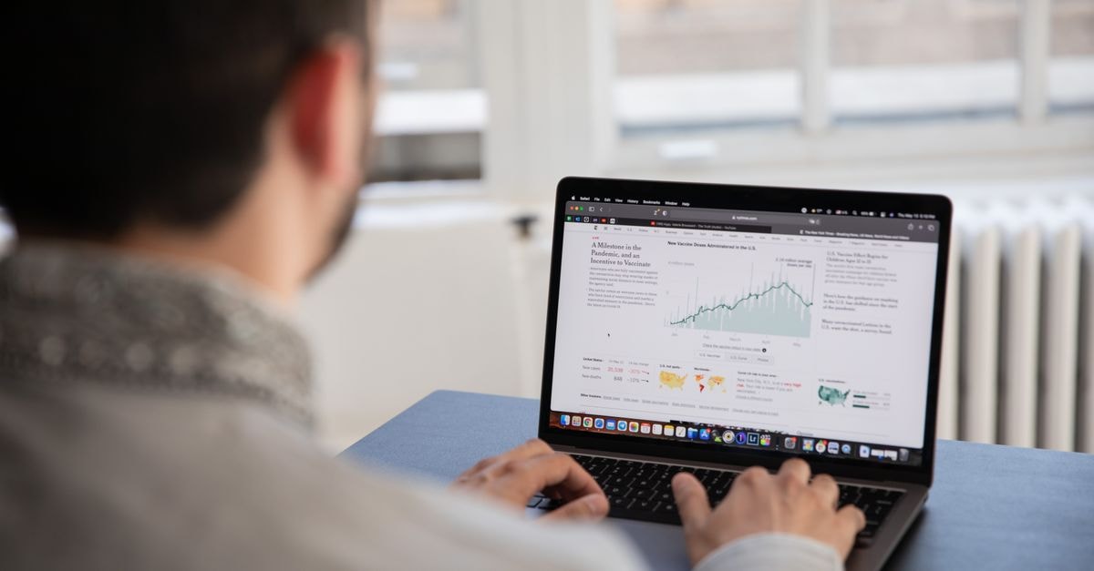 Shopify Rallies After Meta's Muse AI Agent Gains Shop Pay Checkout A person working on a laptop analyzing financial data in a bright indoor setting.