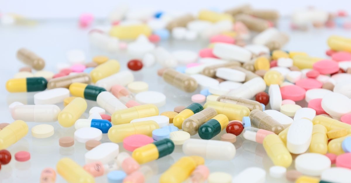 Cencora: Distribution Scale with Acquisition-Led Reshaping A vibrant assortment of pills and capsules scattered across a white surface representing medication and healthcare.