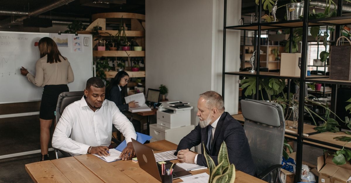 Professional team engaged in a business meeting with diverse members in a modern office environment.