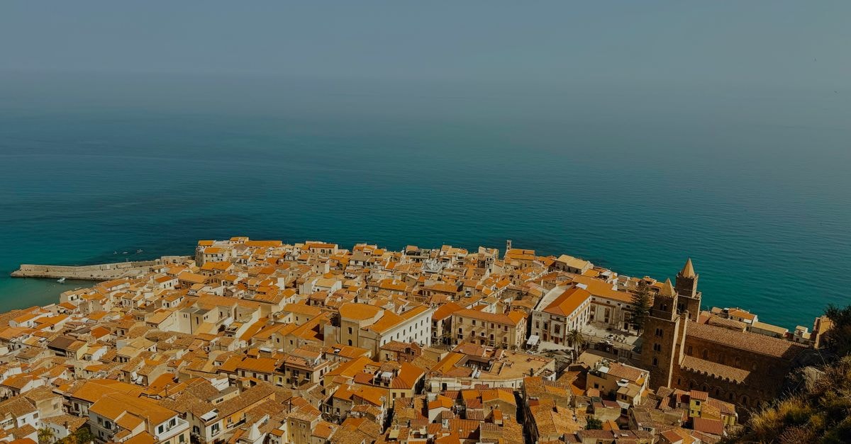 Scenic aerial shot of Cefalù, Italy, showcasing its charming architecture and stunning coastal beauty.