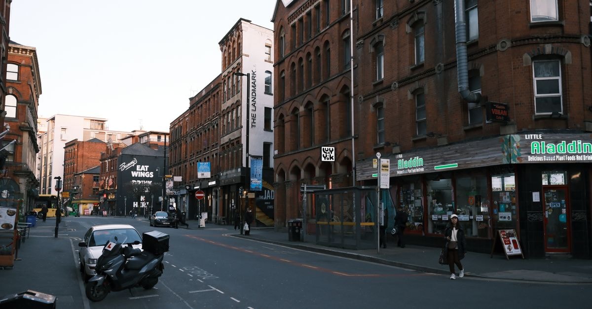 A bustling urban street lined with historic red brick buildings and shops.