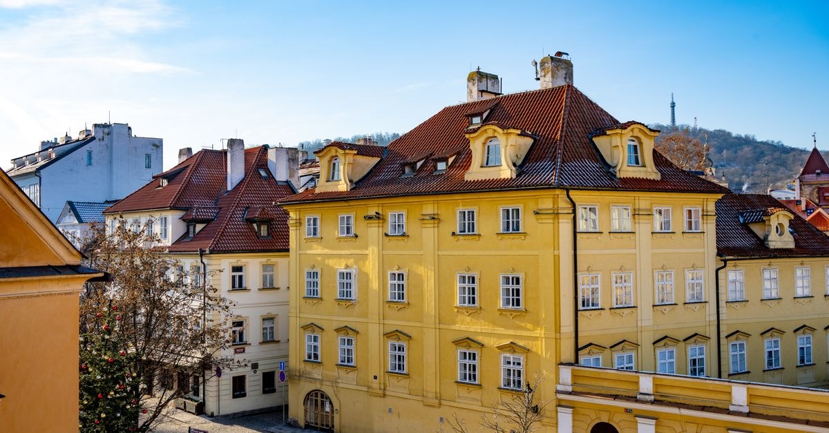 View of colorful historic buildings in Prague with a blue sky backdrop.