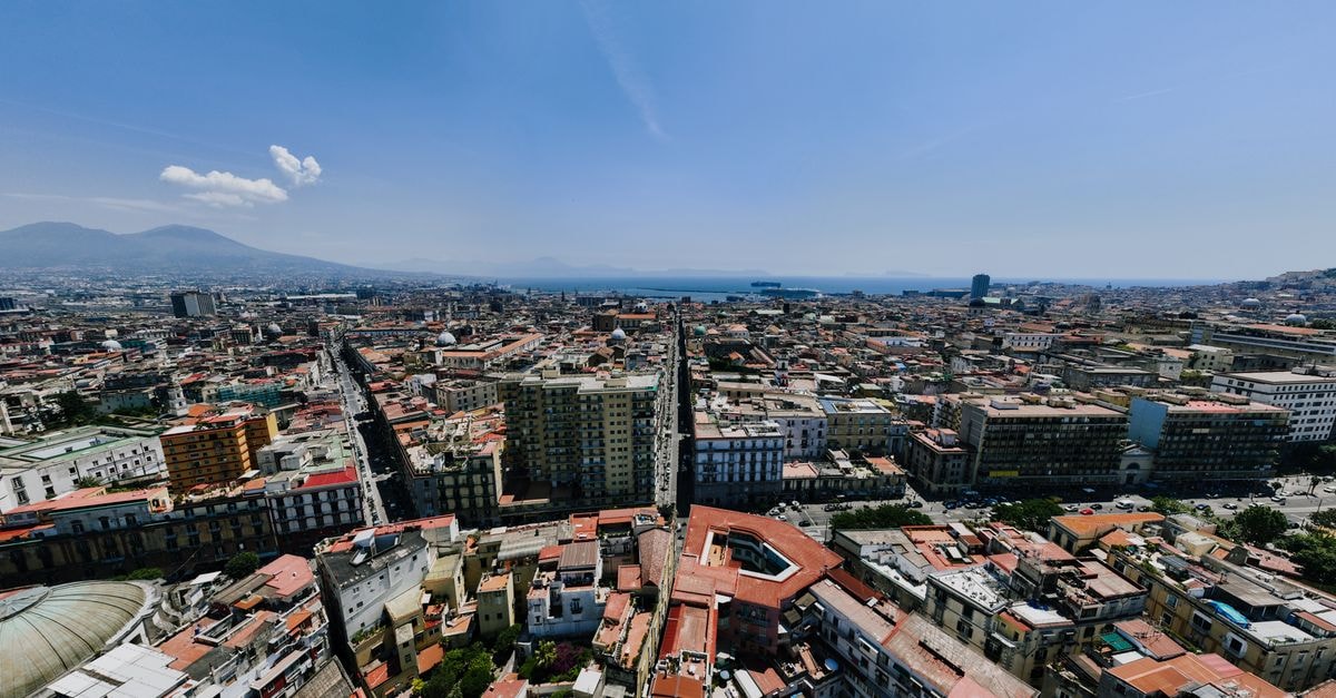 B&B A un passo da, Naples — A New B&B Inside a Historic Palazzo Near Piazza Plebiscito Panoramic aerial shot of Naples, Italy, showcasing cityscape and Mount Vesuvius.