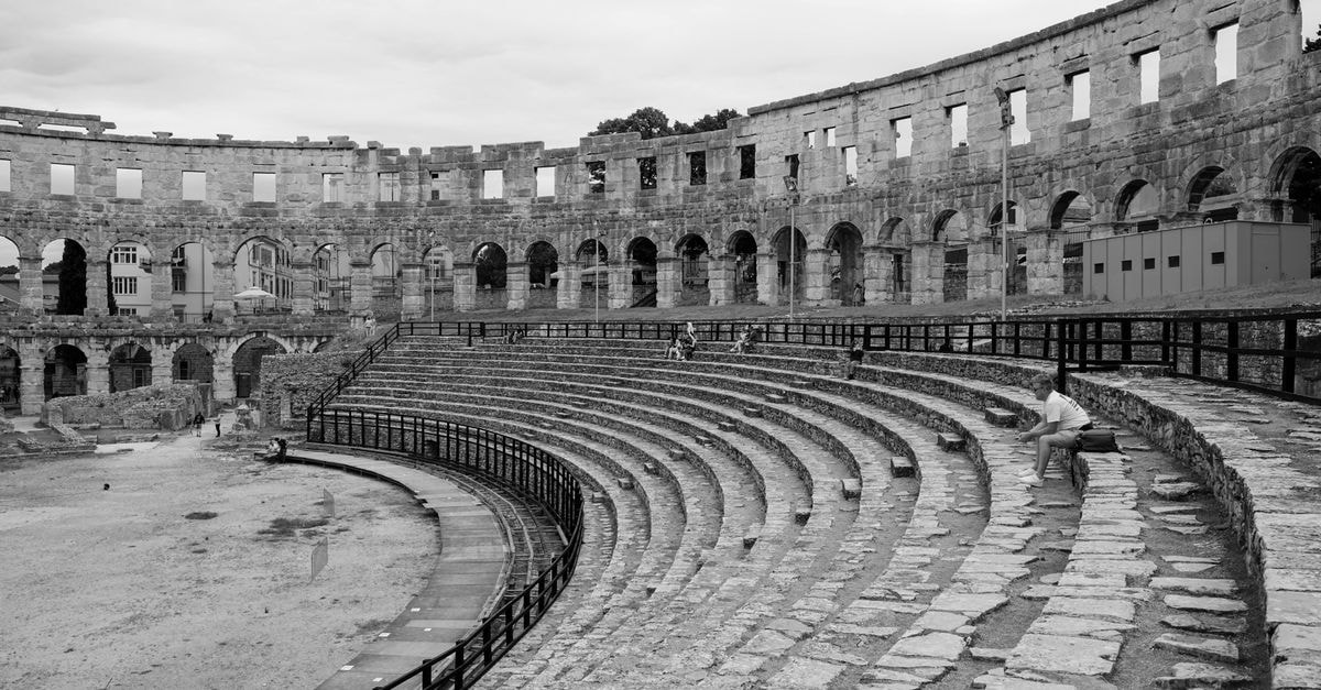 Pula travel guide: sunny Istria with a Roman soul Monochrome image of the historic Pula Arena, a Roman amphitheater in Croatia.
