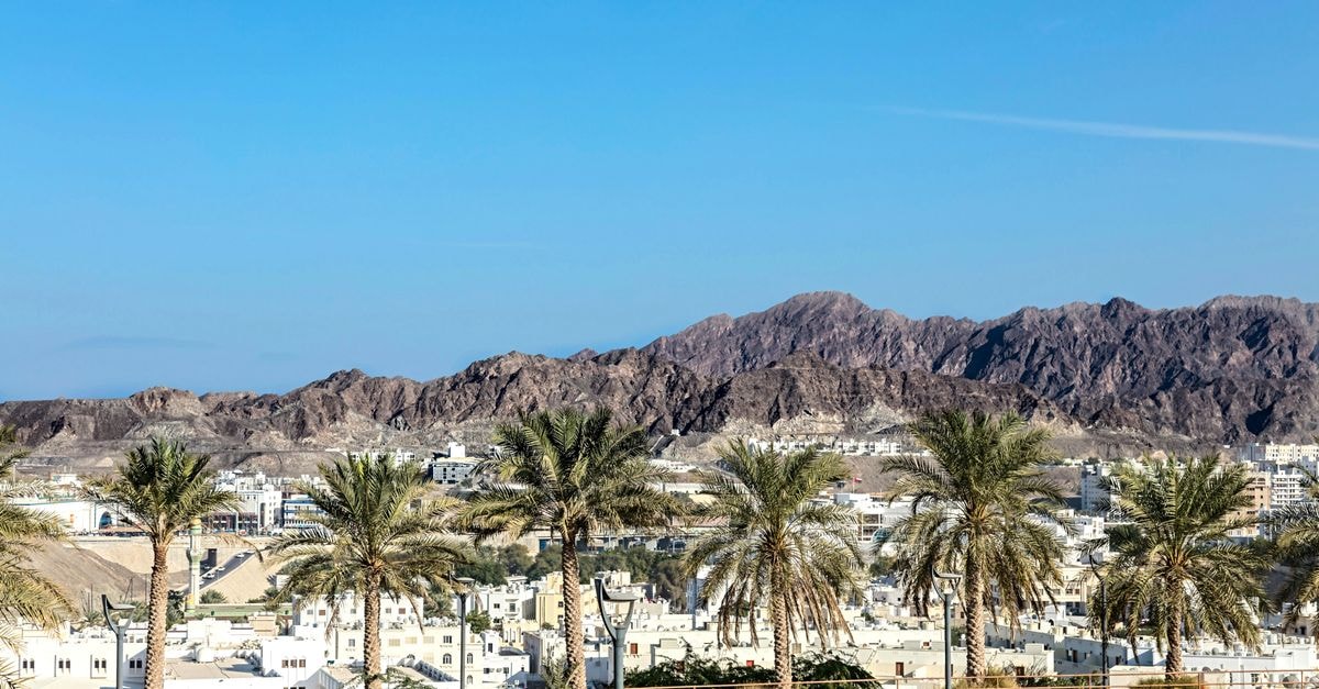 Az Zāwīyah Hotel in Az Zāwīyah, Libya: A Coastal Libyan Base Desert mountains and palm trees under a vibrant blue sky.