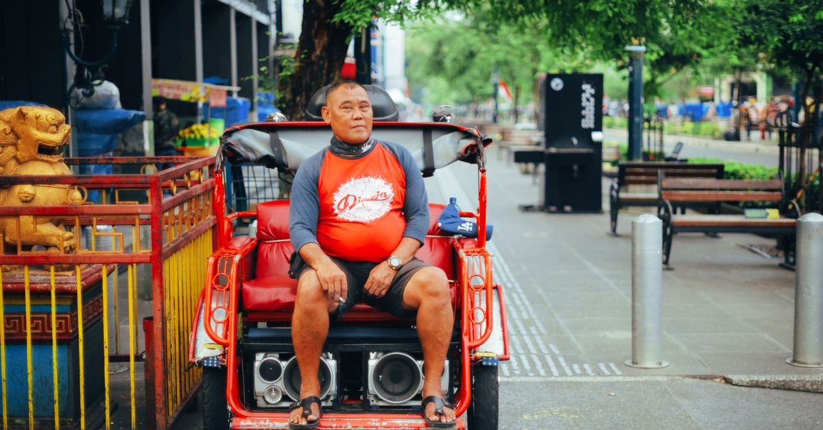 Yogyakarta Travel Guide: Getting Around and Planning Your Days A man sitting on a rickshaw in the vibrant streets of Yogyakarta, Indonesia.