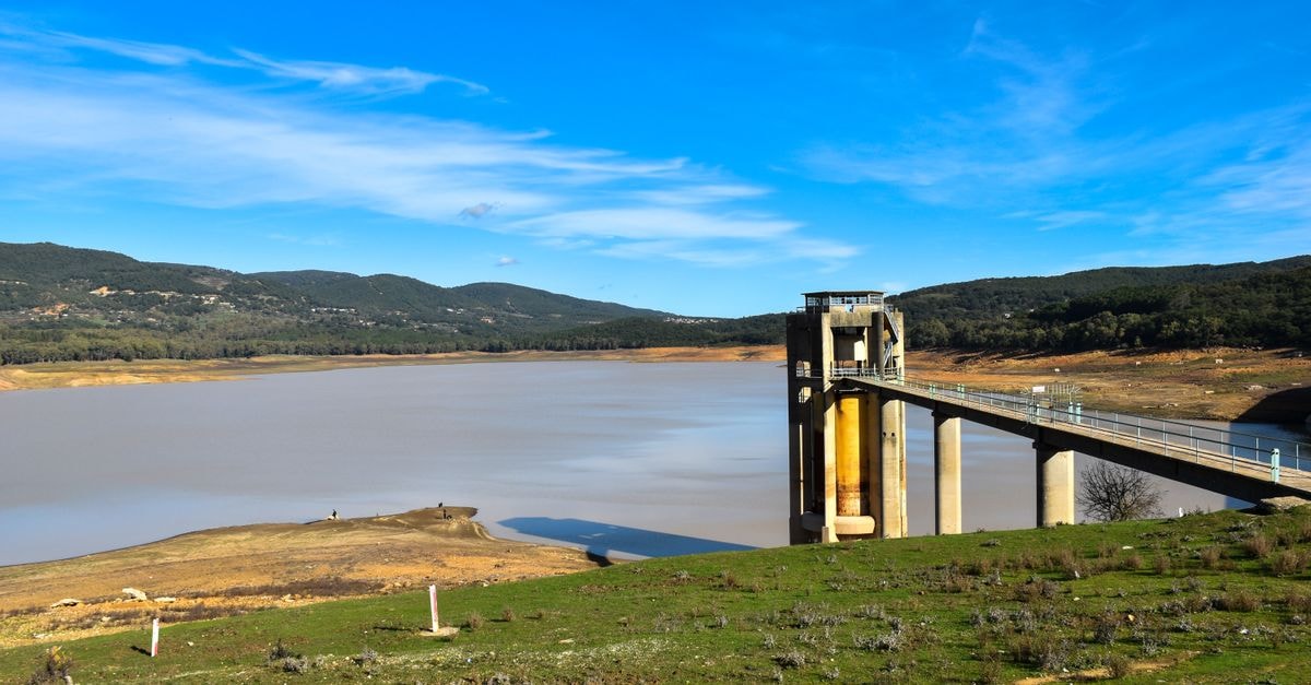 Mingachevir Travel Guide: History, Culture and Reservoir Days Scenic view of Beni M'Tir Dam and reservoir surrounded by hills under a clear blue sky.