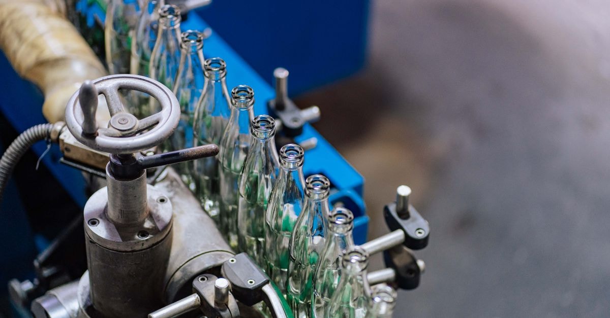 Close-up of glass bottling machinery in action, showcasing industrial precision.