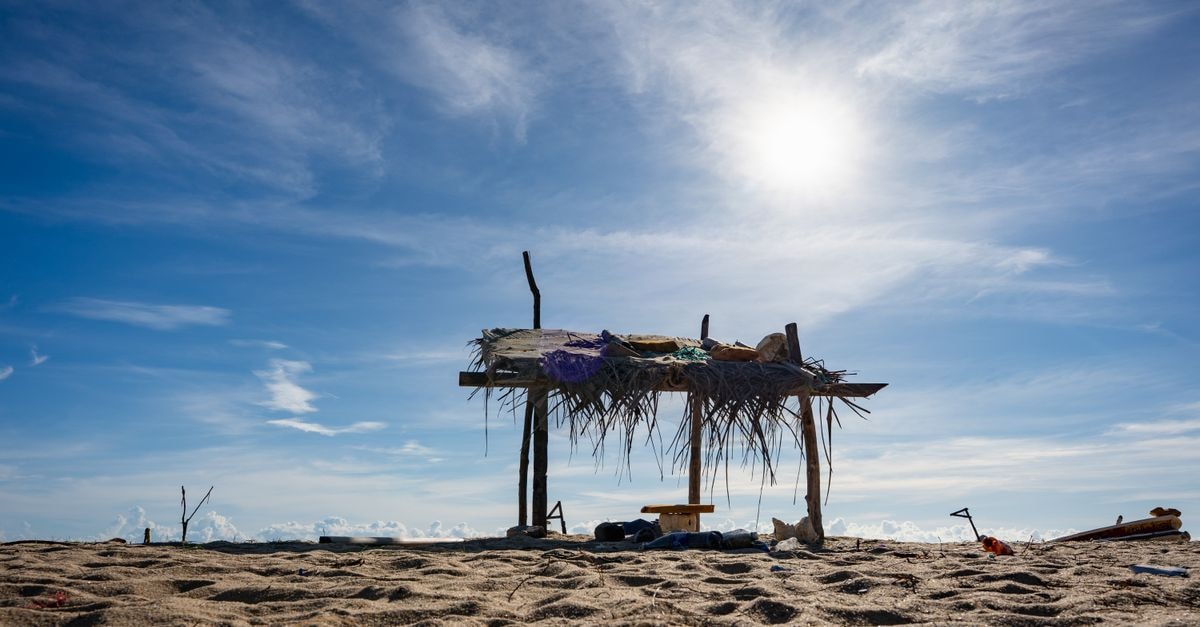 Serrekunda Travel Guide: Beaches, Culture and Local Flavor A simple beach hut on a sandy shore under a bright sunny sky in Batticaloa, Sri Lanka.
