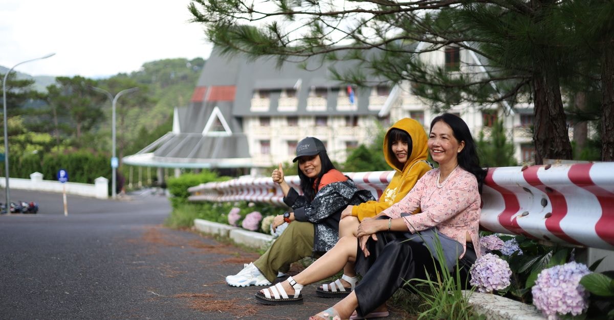Da Lat Travel Guide: Highlands, Cafés, and Cool-Air Cravings Three women sitting outdoors, enjoying a peaceful day in a scenic environment.