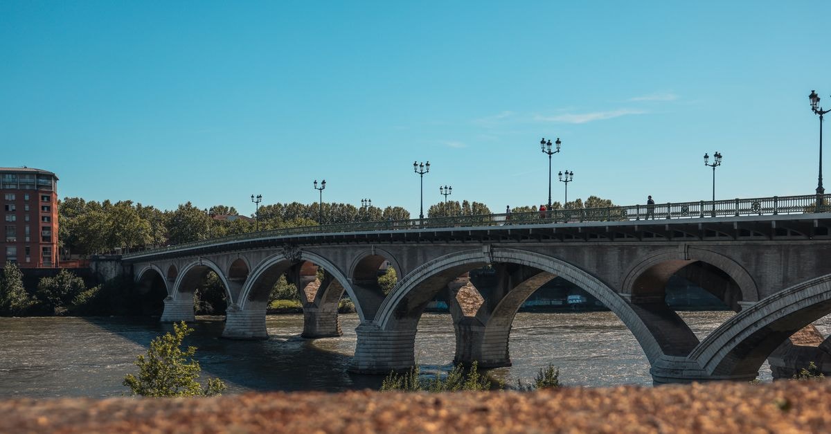 Ours Blanc Victor Hugo in Toulouse: A Soundproofed Stay on Rue du Rempart Matabiau Scenic view of Pont Saint-Pierre bridge crossing the Garonne River in Toulouse, France.