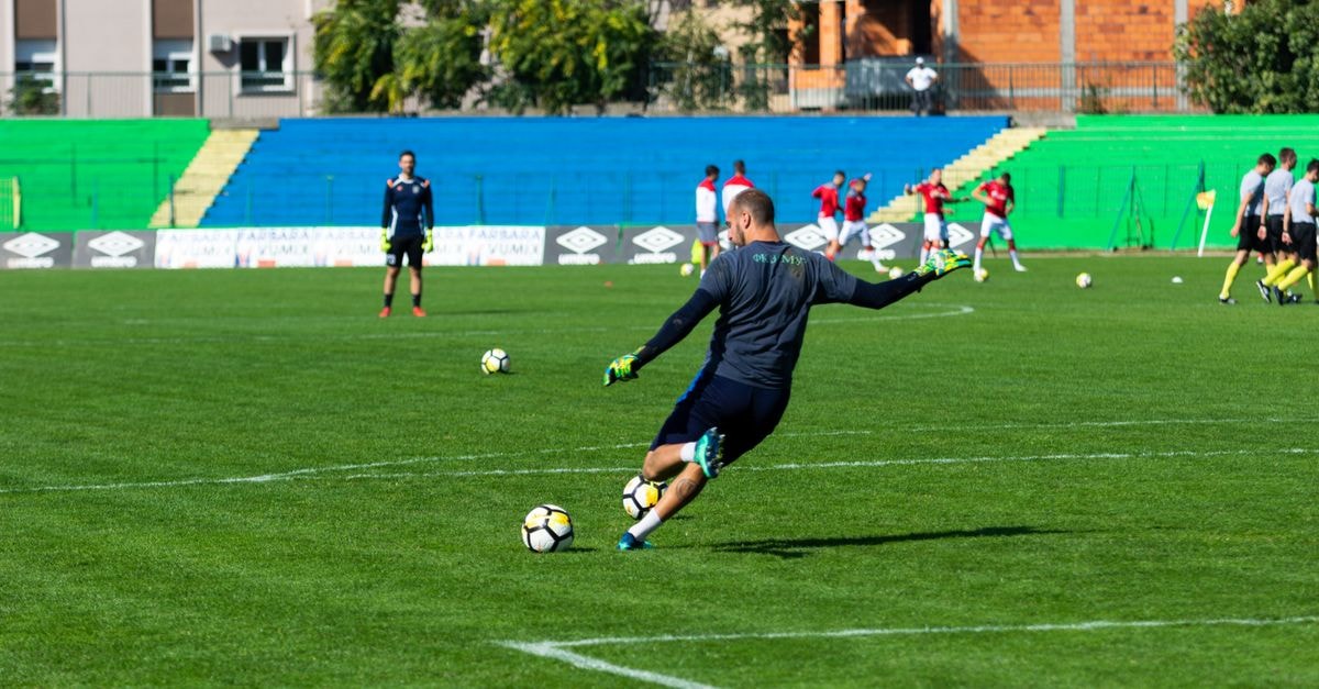 Florida State men's basketball lands first jersey patch deal with ReliaQuest Soccer player in action during practice on a sunny day, kicking the ball on a green field.