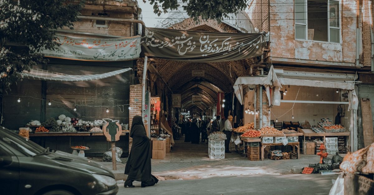 Khorramabad travel guide: a layered Lorestan city of food and memory Traditional street market with vibrant stalls and arched entrance in an urban setting.