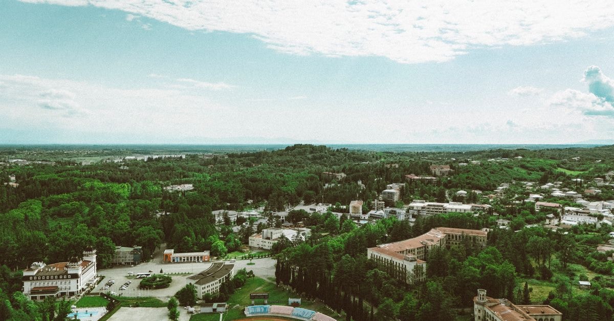 Hostel "Full house" in Rivne — Capsule and Apart-Hotel Living Side by Side Aerial shot of a lush and serene cityscape in Georgia, showcasing green landscapes and architecture.