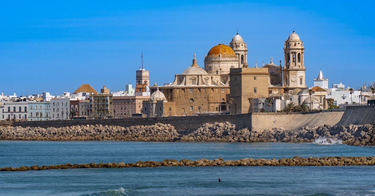 Melilla Travel Guide: A Spanish Pocket on the Mediterranean Scenic view of Cádiz Cathedral and waterfront, capturing iconic Andalusian architecture against a clear blue sky.