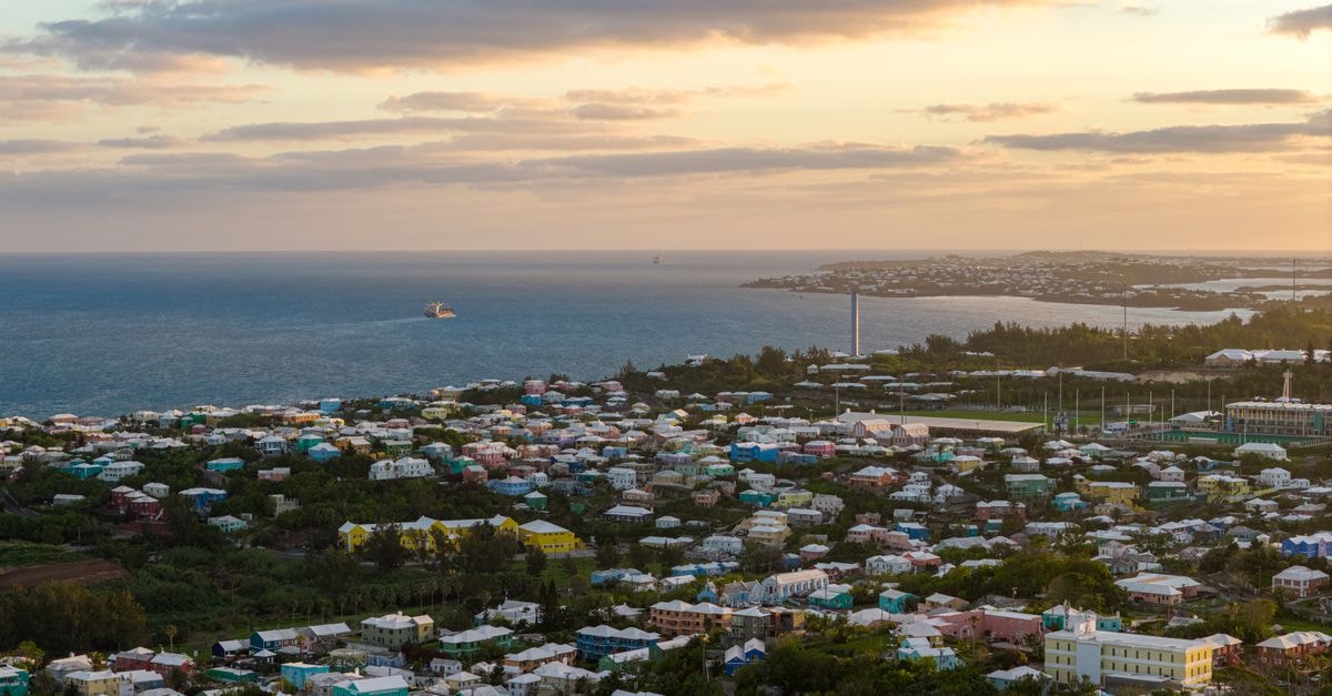 Villa Jessica in Moroni: A Boulevard Karthala Stay on the Islands of Moon and Scent Stunning aerial view of Bermuda's coastal town with vibrant houses and ocean at sunset.