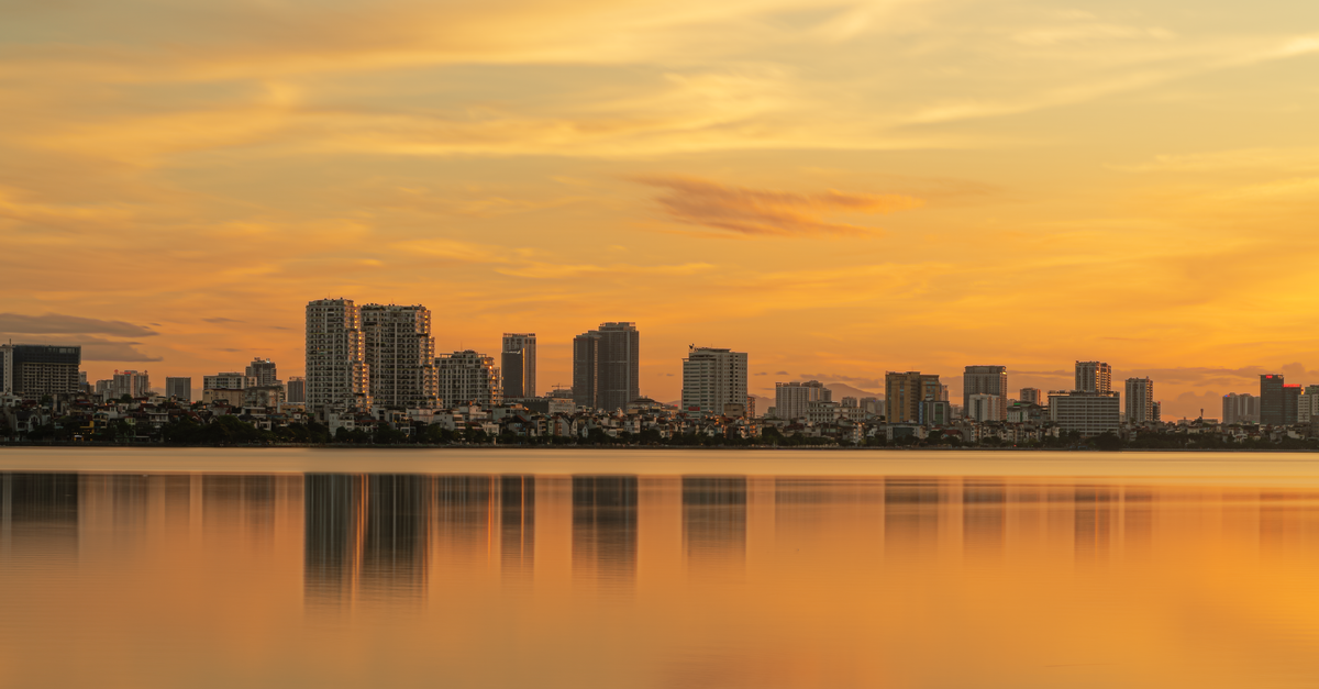 Tru by Hilton Hanoi Station: Colorful Lobby on Tran Hung Dao Street Beautiful sunset view of the Hanoi skyline reflected on West Lake, capturing urban tranquility.