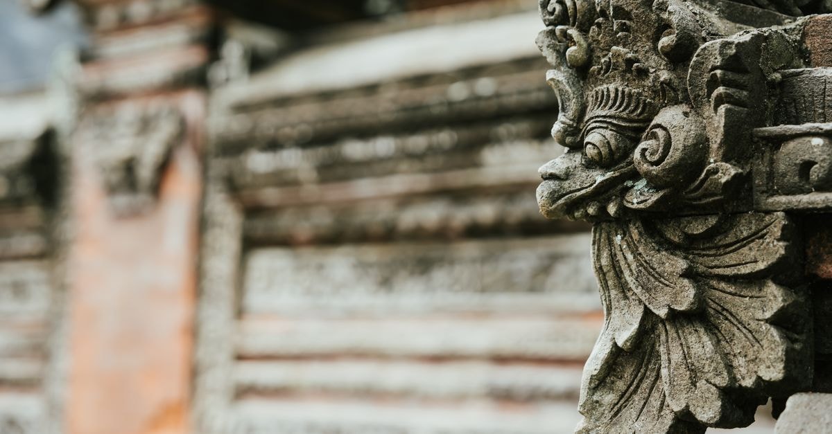 Jepara Travel Guide: Carving Heritage and Island Calm Close-up of an intricate stone carving on a traditional Balinese temple wall, showcasing cultural artistry.