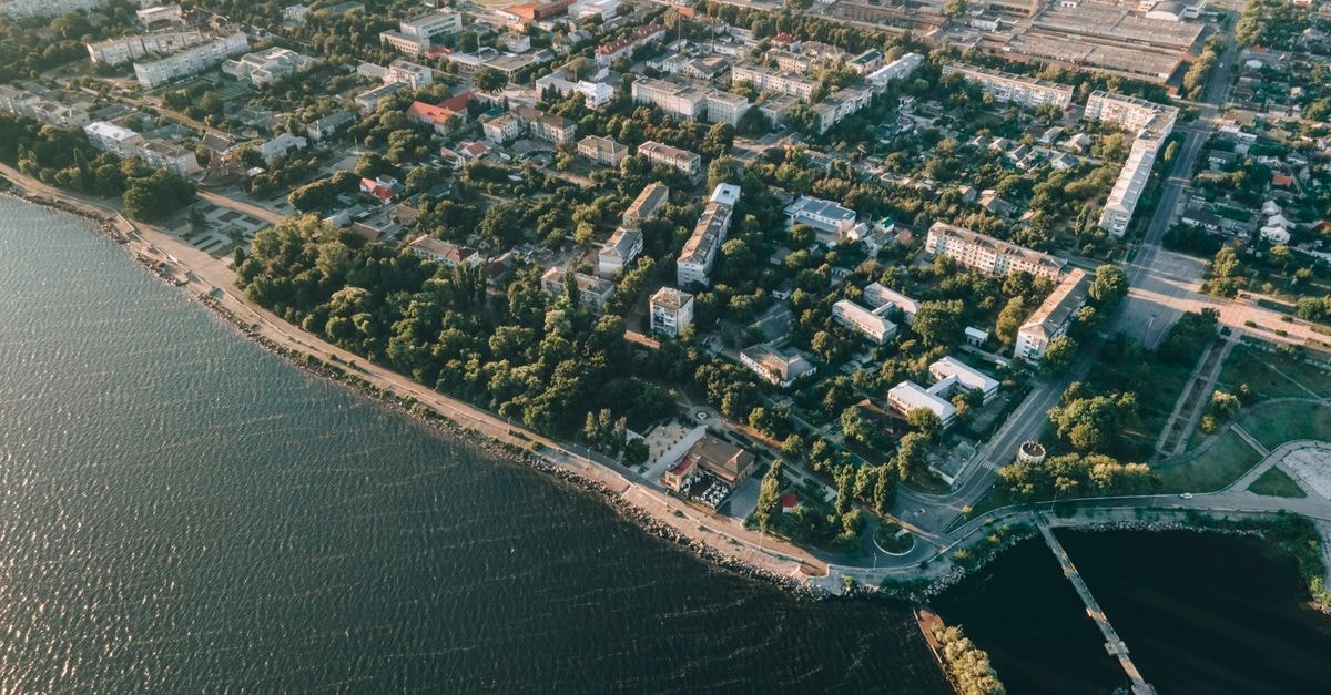 Aerial view depicting a serene coastal town with lush greenery and clear water.
