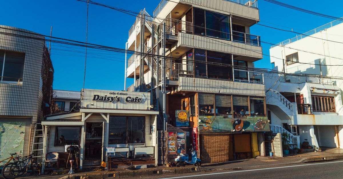 Fukuyama Travel Guide: Quiet Stops and Local Flavors Vibrant street view of Daisy's Cafe in Kamakura, Japan, showcasing local architecture.