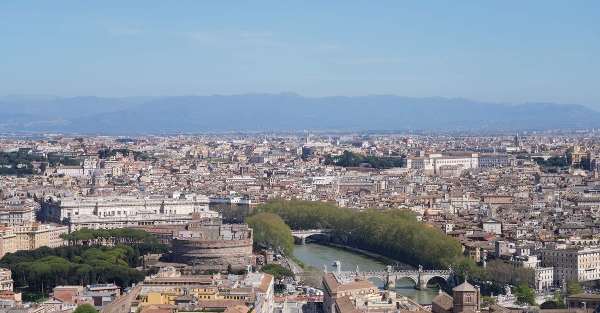 Thompson Hotel Rome: Heritage Palazzo Near Piazza Venezia and the Pantheon A breathtaking aerial view of Rome featuring Castel Sant'Angelo and the Tiber River, showcasing the city's iconic landmarks.