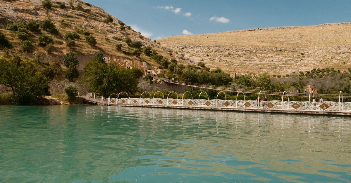 A Quiet Riverside Pause in Turkmenabat: Eastern Hub Travel Guide Tranquil landscape of Euphrates River in Halfeti, with serene water and rugged hills.